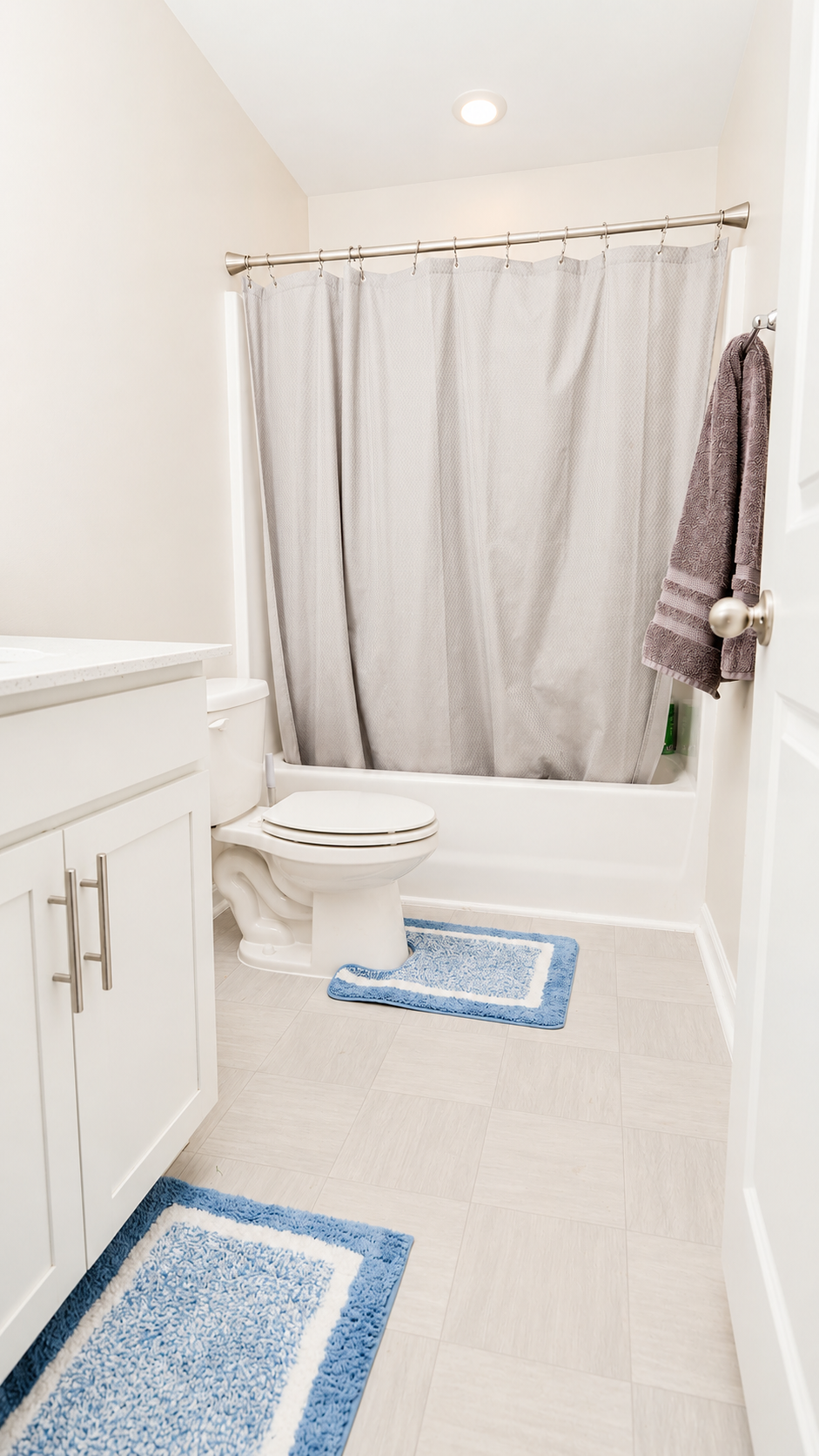 Secondary full bathroom with tub-shower combo and white vanity