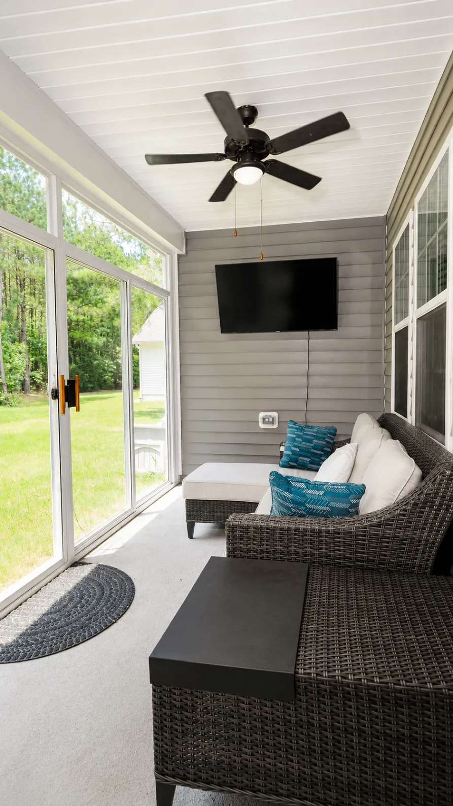 Screened porch at 222 Lothian with lounge seating and a television