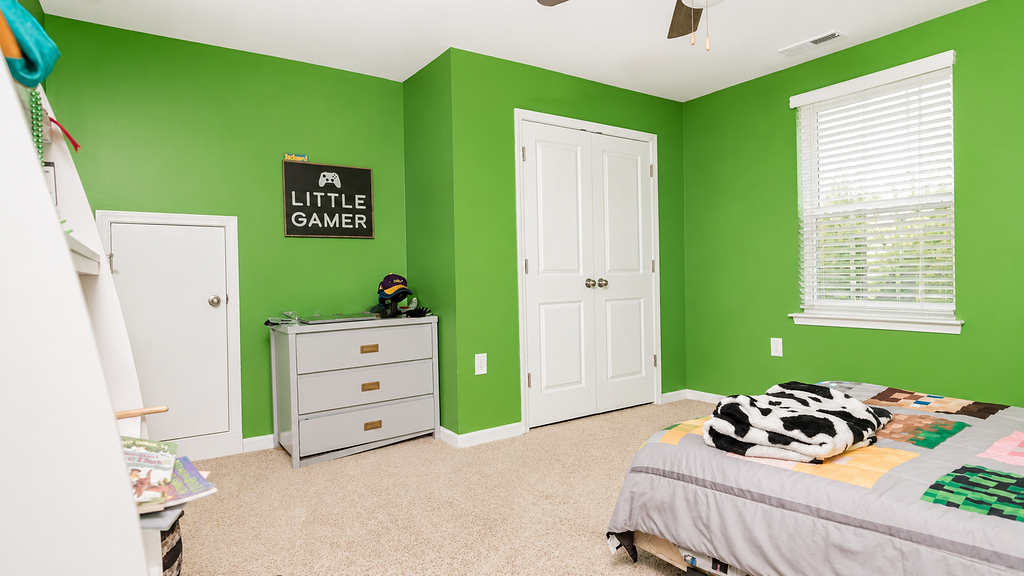 Playful kids bedroom with green walls, double closet and dresser